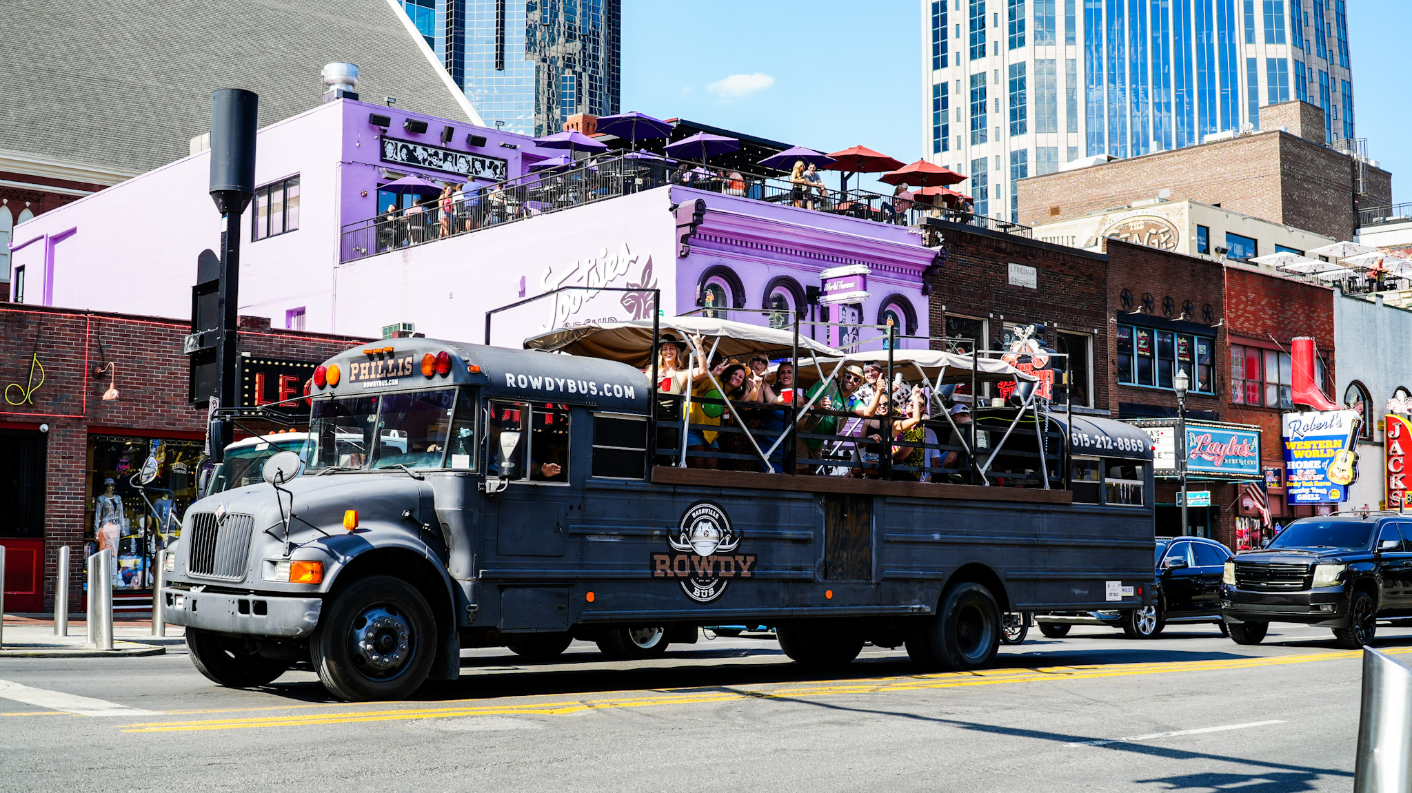 Rowdy Bus - Black luxury shuttle with passengers enjoying the ride through downtown Nashville