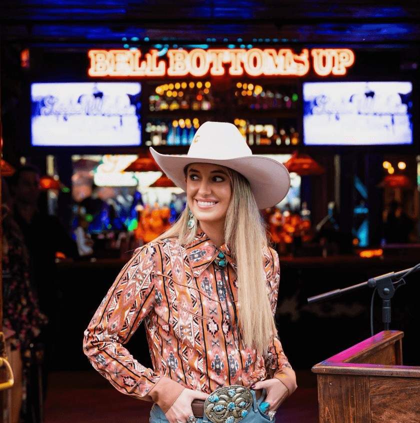 Lainey Wilson smiling in a cowboy hat at Bell Bottoms Up bar.