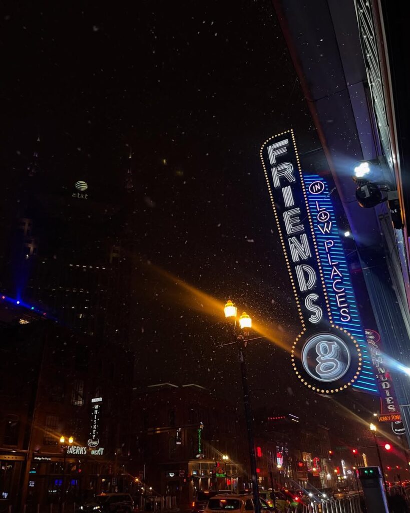 Broadway in Nashville at night, with neon lights from Friends in Low Places and nearby honky-tonks glowing in the dark.