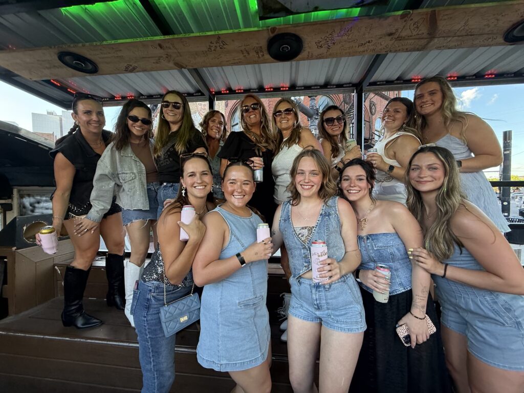 Friends in denim on a Rowdy Bus open-air party bus in downtown Nashville